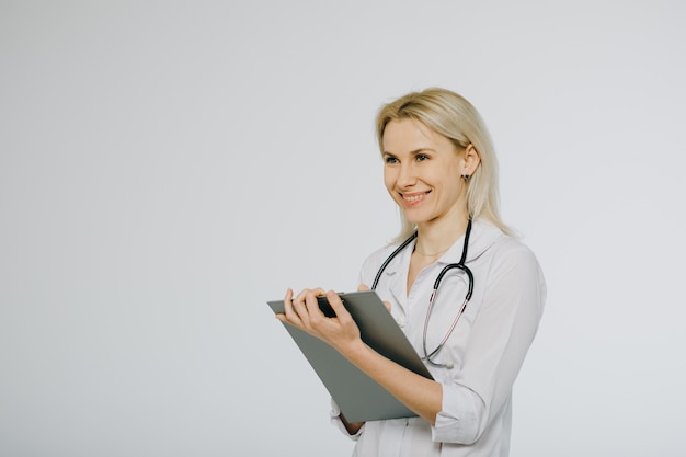 Female doctor with stethoscope writing prescription. healthcare and medical concept