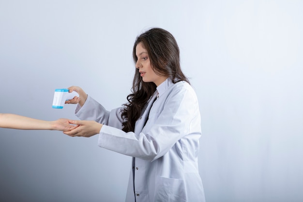 female doctor with thermometer checking someone's temperature. 