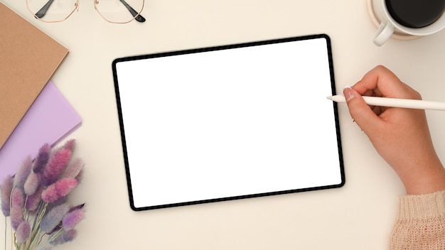 Female drawing on a digital tablet touchpad in her stylish workspace Tablet white screen mockup