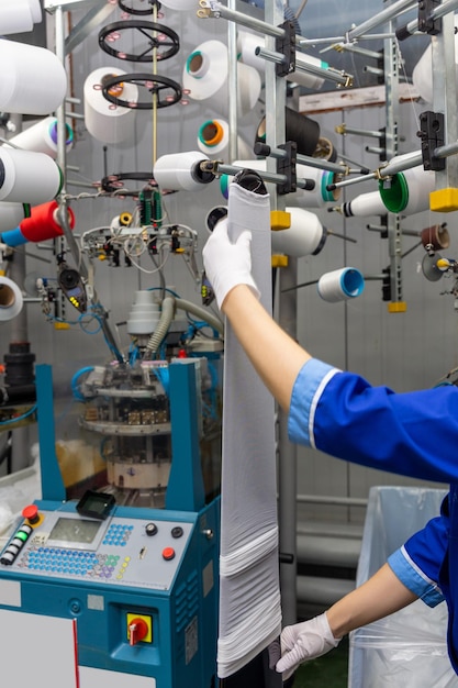 A female employee performs visual quality control of hosiery