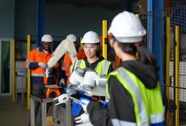 Female Engineer check and control automation robot arms machine in intelligent factory industrial on real time monitoring system software robotics and digital manufacturing operation