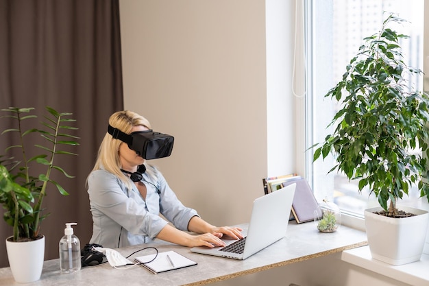 Female engineer working on computer creating a racecar using VR virtual reality glasses and controller. Concept for women in hightech jobs.