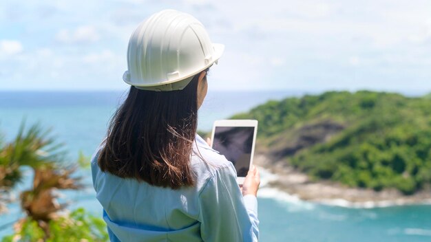 Female engineer working on the seaside wearing a protective helmet x9