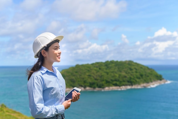 Female engineer working on the seaside wearing a protective helmet x9