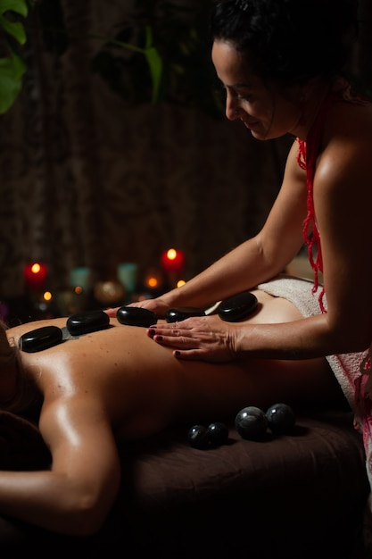 Female enjoying relaxing back massage in cosmetology spa centre.