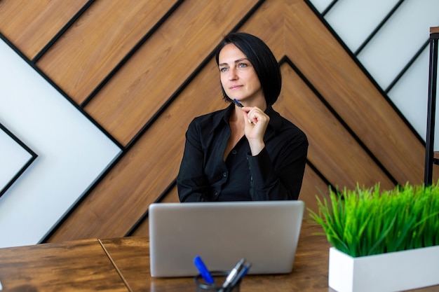 A female executive holds a meeting in the office with a laptop