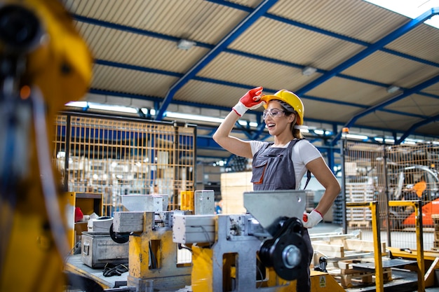 Female factory worker operating industrial machine in production line.