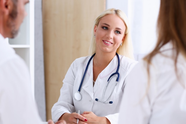 Female family doctor listen carefully young couple