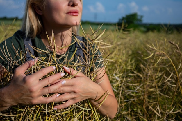 Photo female farmer gently embraces the rapeseed yield