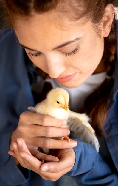 Female farmer holding a baby chicken