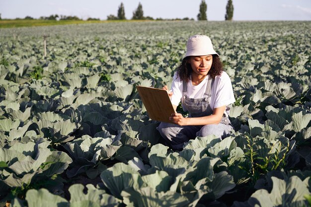 Photo female farmer making notes in clipboard on field during harvesting agricultural concept