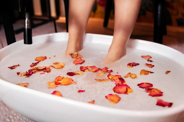 Female feet put in a bucket for a pedicure