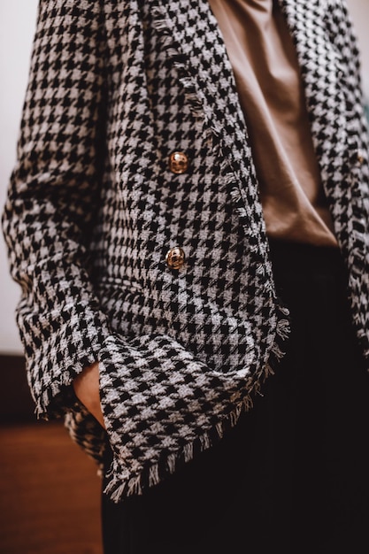 Female figure dressed in a black and white checkered stylish jacket