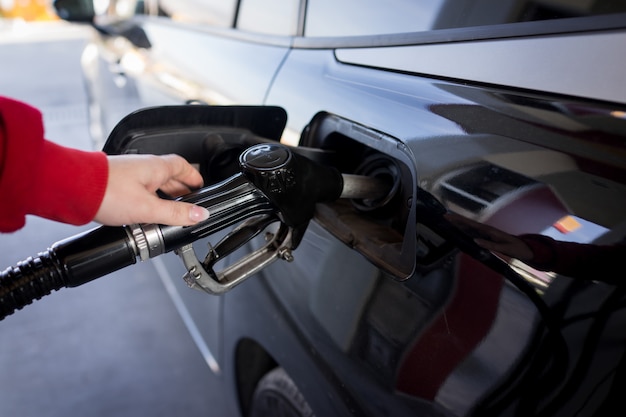 Female filling petrol in a car