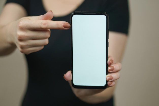 The female finger points to the phone white screen