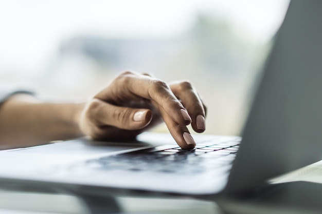 Photo female finger presses a button on a laptop keyboard business and technology concept close up