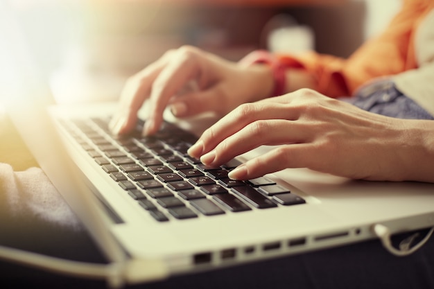 Female fingers on a laptop.