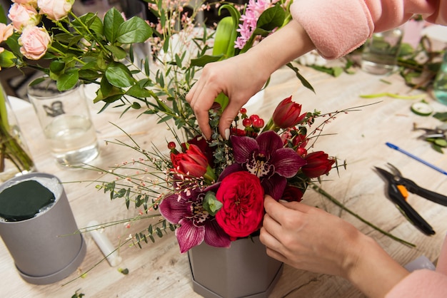 Female florist hands arranging floral composition