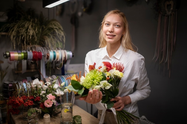 Photo female florist holding a beautiful bouquet