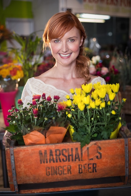 Photo female florist holding crate of flower bouquet