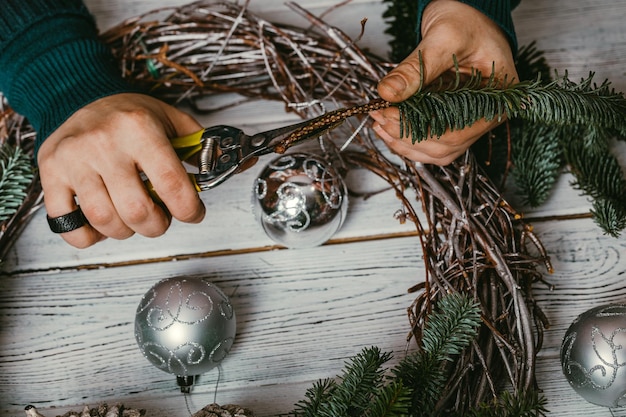 Female florist making Christmas wreath in flower shop