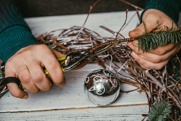 Female florist making Christmas wreath in flower shop