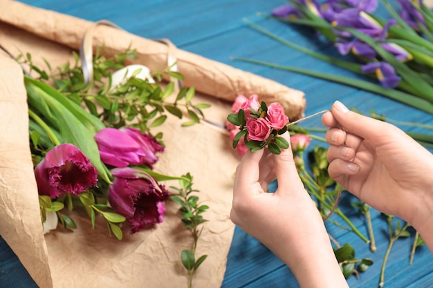 Female florist making floral composition on wooden table