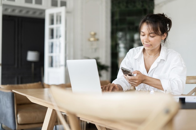 A female freelancer works in an office online doing a design project on a website The programmer