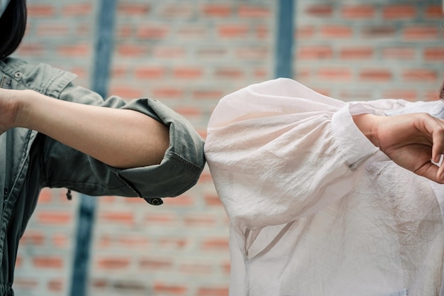 Female freelancers wearing face masks salute elbow bumps in the workplace new normal covid19