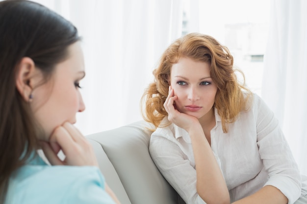 Female friends sitting on sofa in the living room