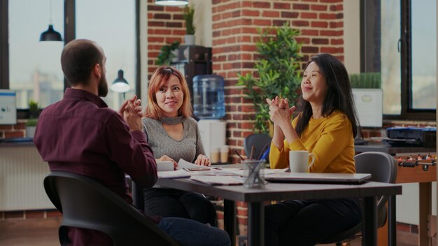 Photo female friends using mobile phone while sitting at restaurant