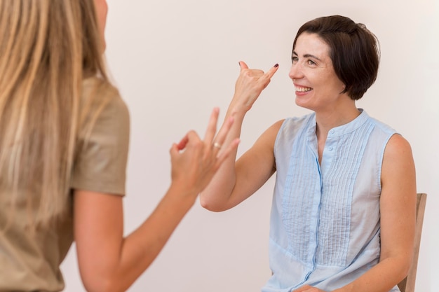 Photo female friends using sign language to talk to each other