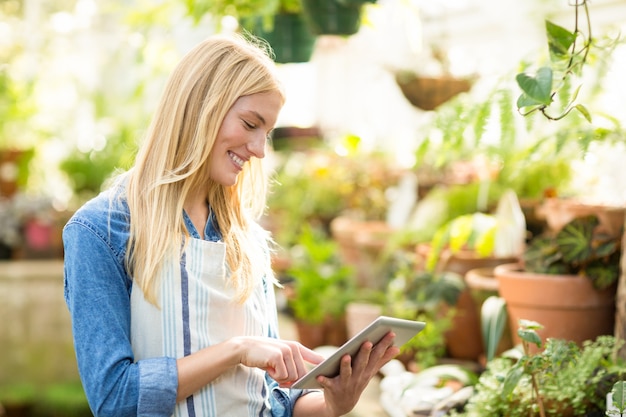 Female gardener using digital tablet at greenhouse