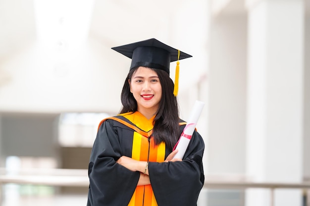 Female graduates wear black gowns and yellow tassels waiting to attend the commencement ceremony at the university