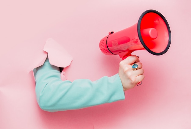 Female hand in classic blue jacket with megaphone