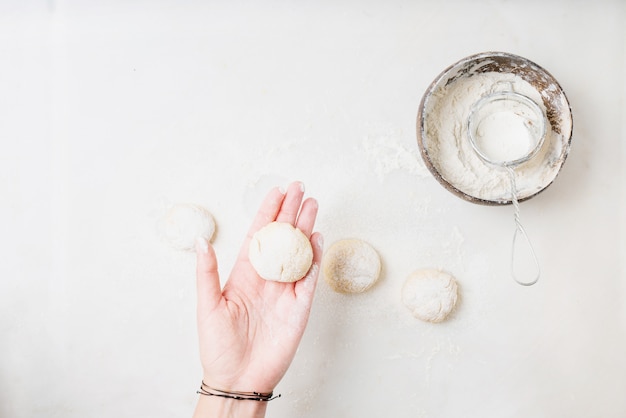 Female hand forming dough balls