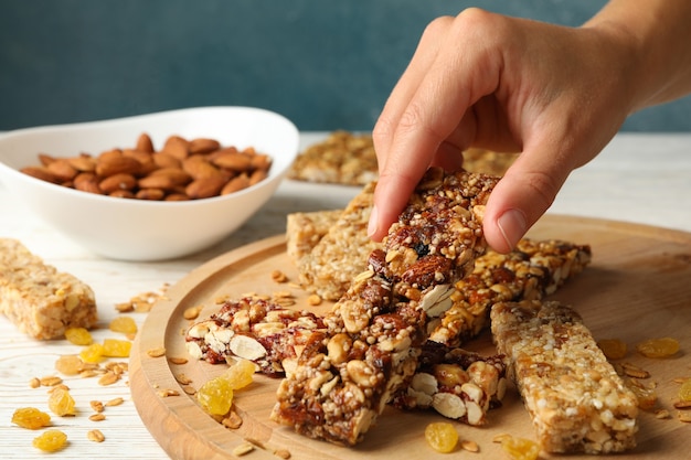 Female hand hold granola bar on wooden background