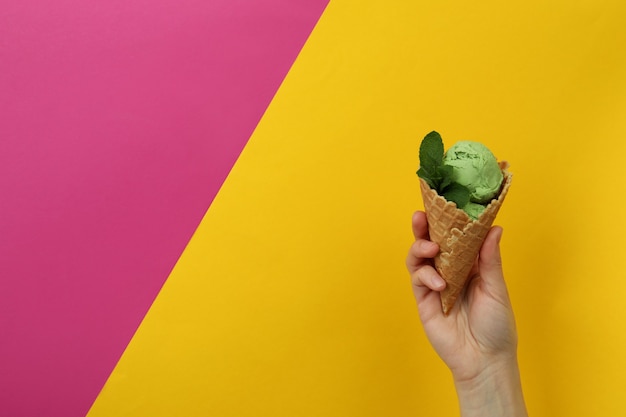 Female hand hold mint ice cream on two tone