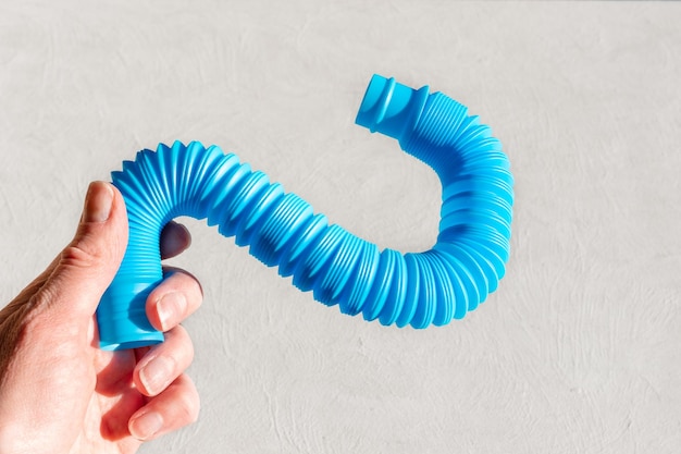 Female hand holding an antistress sensory pop tube on a white background Coping with stress in adults Relaxation for adults Game for the development of imagination and fine motor skills