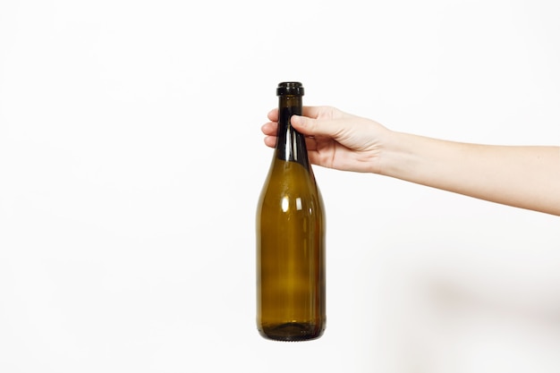 Female hand holding bottle of champagne or wine isolated on a white background.