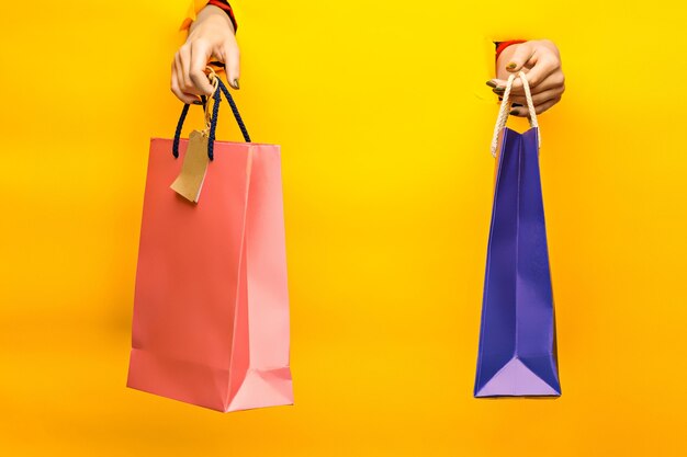 Female hand holding bright shopping bags