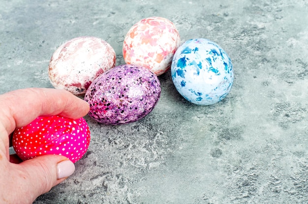 Female hand holding brightly colored easter eggs. Studio Photo