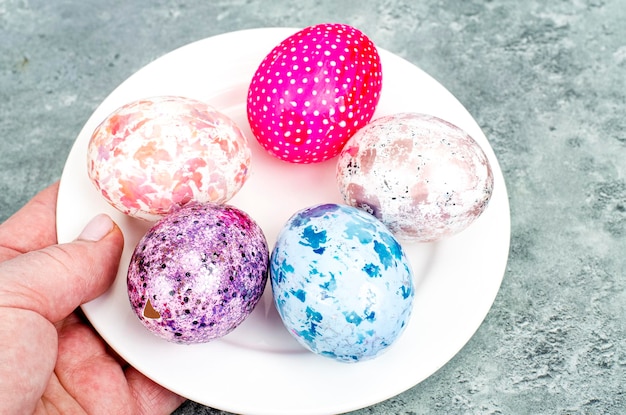 Female hand holding brightly colored easter eggs. Studio Photo