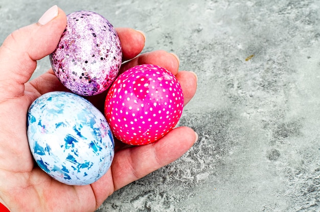 Female hand holding brightly colored easter eggs. Studio Photo