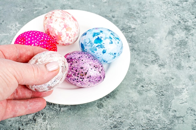 Female hand holding brightly colored easter eggs. Studio Photo