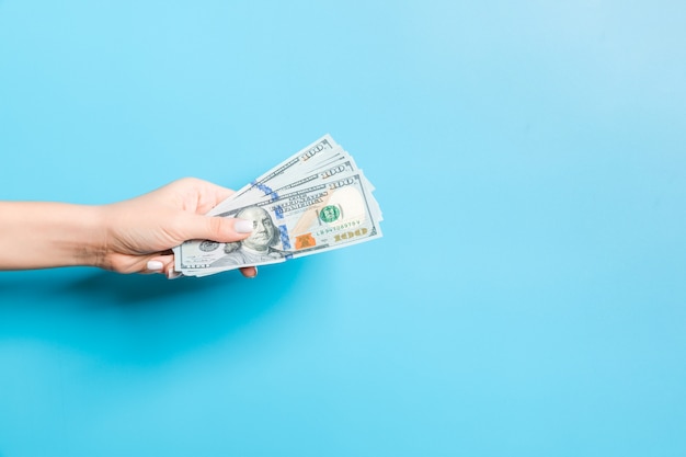 female hand holding a bundle of dollars 