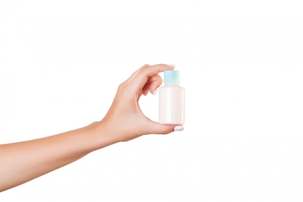 Female hand holding cream bottle