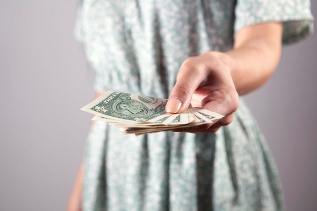 Female hand holding one hundred dollar bills