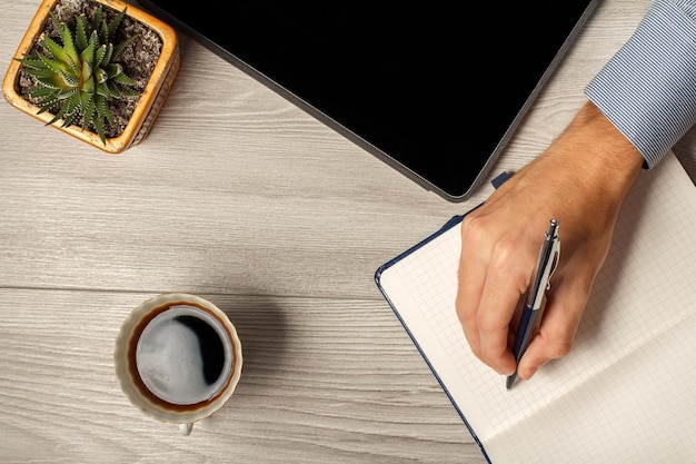 Female hand holding a pen ready to take notes in a notebook