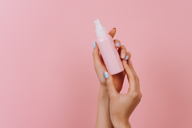 Female hand holding a reusable beauty bottle Skin care and anti aging concept Top horizontal view copy space